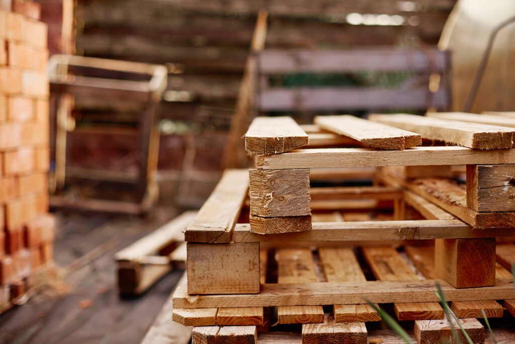 Wooden pallets lie on top of each other in the garden.